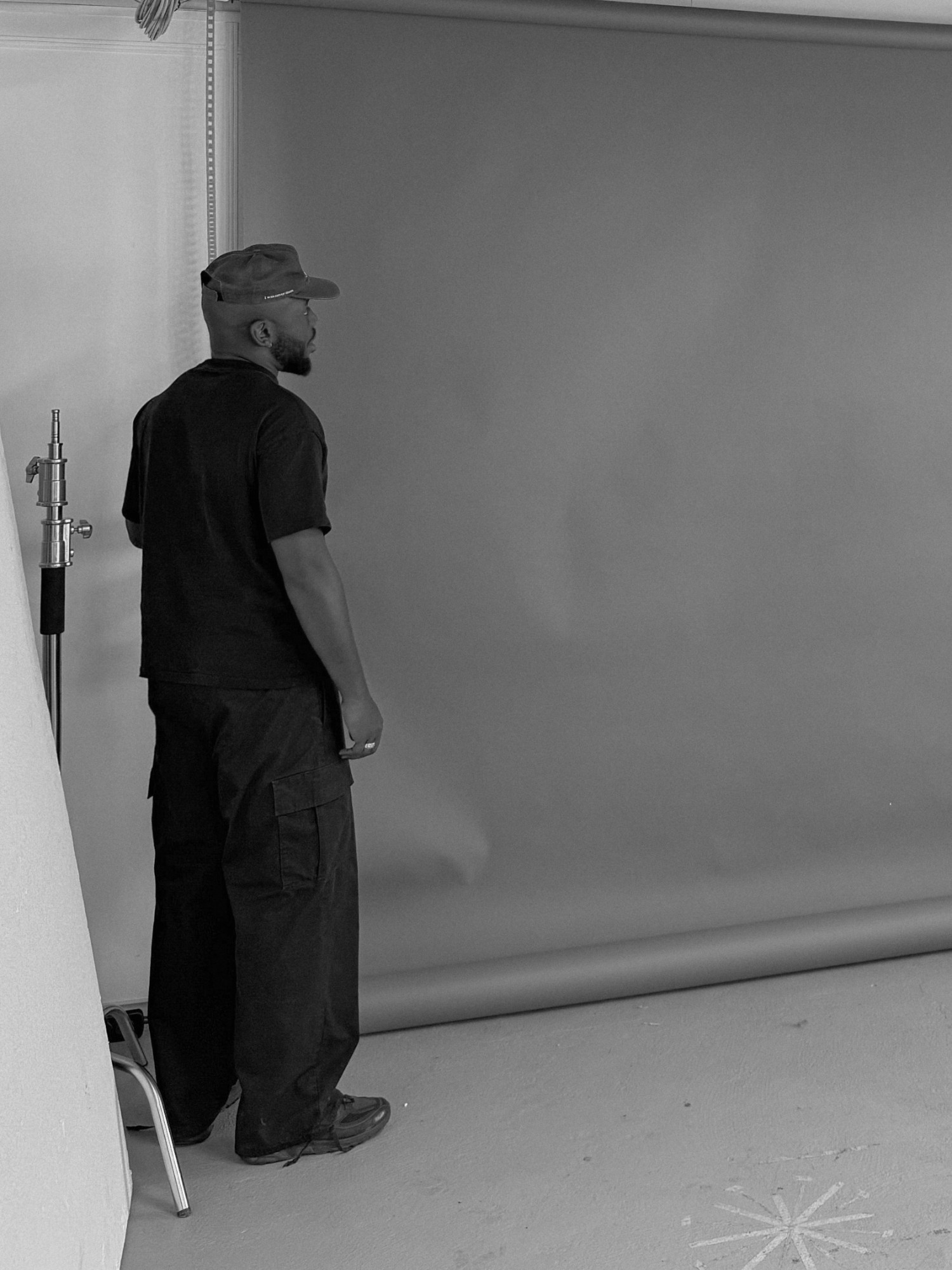 Jay Dogo dans le studio, de dos, devant le fond de prise de vue