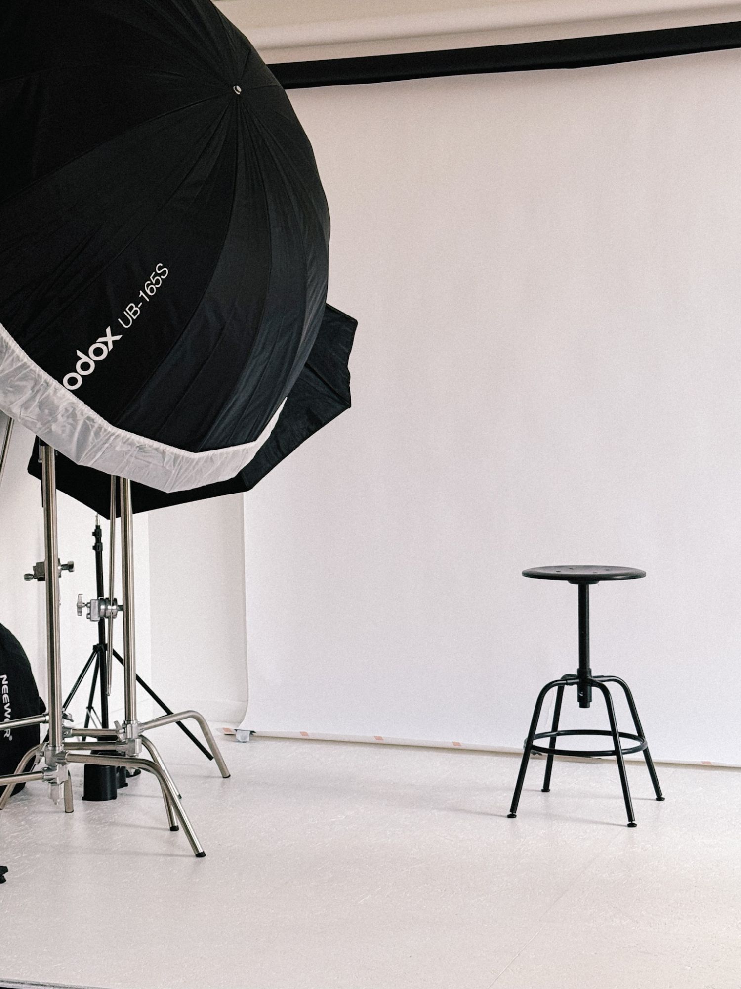 Le plateau du studio : fond blanc, tabouret et grande parabole de lumière