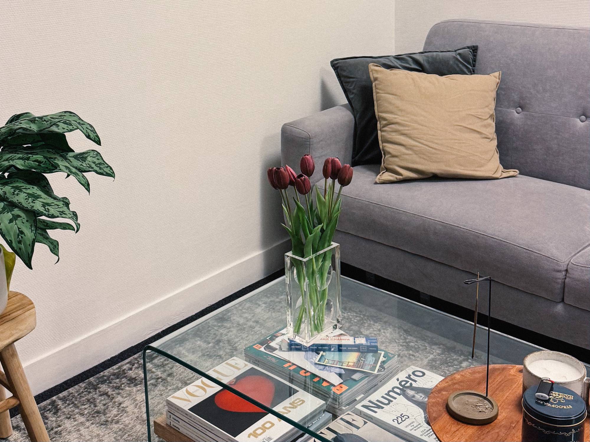 Le coin salon du studio : canapé, tulipes et magazines de mode